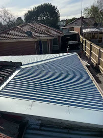 Metal roof with a house in the background