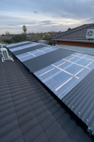 Solar panels installed on a roof with a clear sky in the background