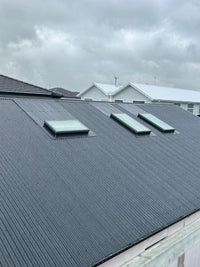 Roof with solar panels on a cloudy day - Bill Roofing 